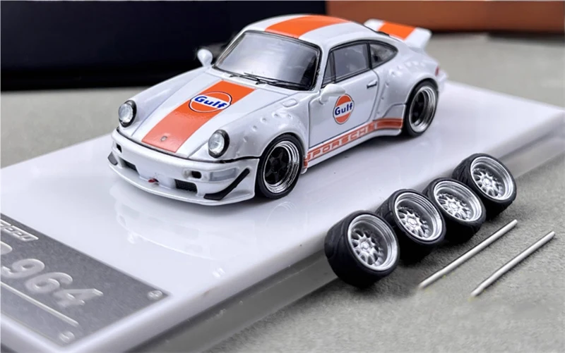 White RWB964-style model car with Gulf racing colors, displayed with four spare wheels