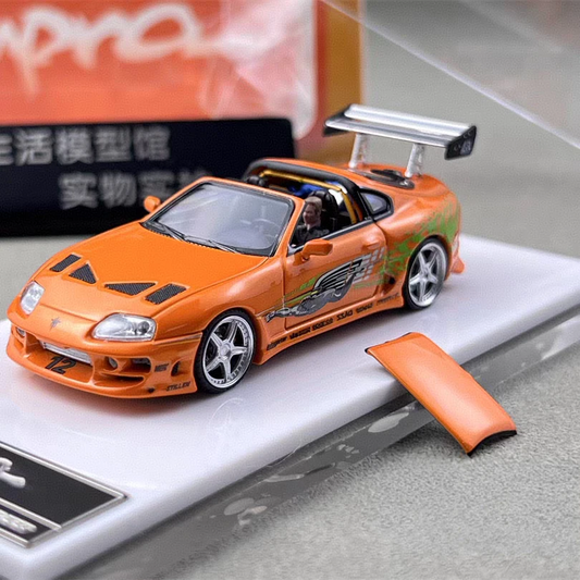 Orange modified A80 Targa-style model car with silver wheels, rear wing, and Brian O’Conner figure in the cockpit